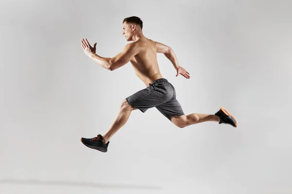 Hombre Musculoso Seguro Con Cuerpo Perfecto Corriendo Sobre Fondo Blanco —  Fotos de Stock