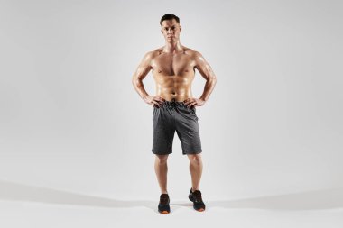 Beyaz arka planda dururken el ele tutuşan yakışıklı kaslı adam.