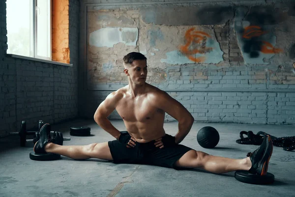 Passade Ung Man Hålla Händerna Höften Medan Gör Splittringar Gymmet — Stockfoto