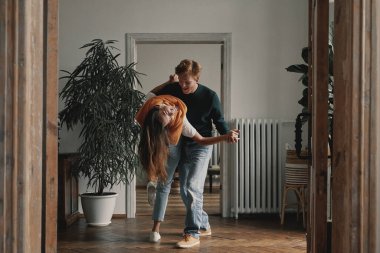 Evlerinde dans eden neşeli genç bir çift.