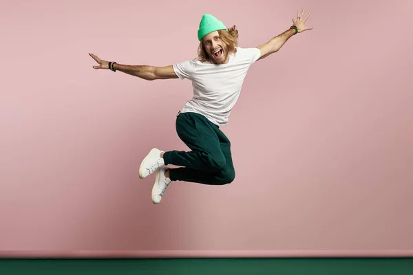 Guapo Joven Buscando Feliz Mientras Salta Sobre Fondo Colorido — Foto de Stock