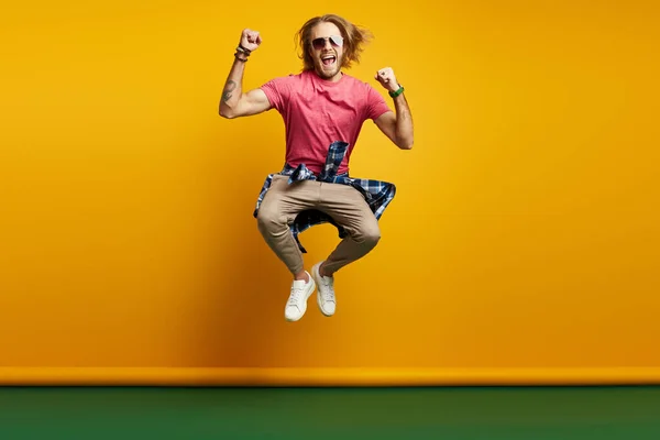 Emocionado Joven Haciendo Gestos Mientras Salta Sobre Fondo Amarillo — Foto de Stock
