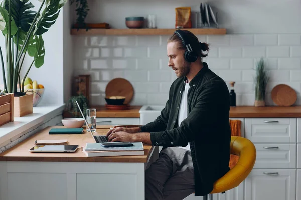 Hombre Confiado Los Auriculares Que Trabajan Ordenador Portátil Mientras Está — Foto de Stock
