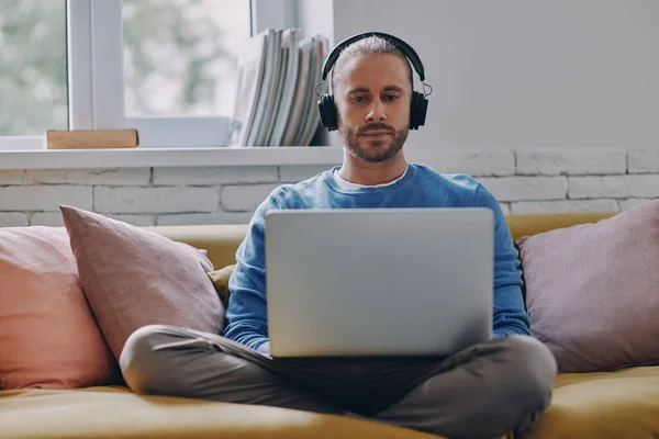 Joven Confiado Los Auriculares Que Trabajan Ordenador Portátil Mientras Está — Foto de Stock