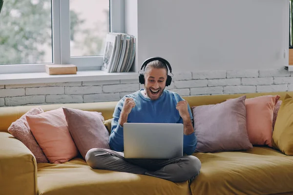 Joven Emocionado Con Auriculares Mirando Computadora Portátil Haciendo Gestos Mientras — Foto de Stock