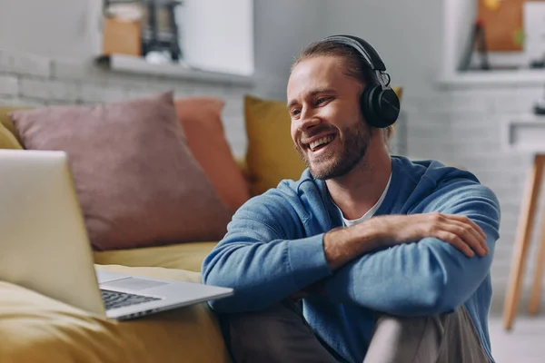 Hombre Guapo Auriculares Mirando Computadora Portátil Sonriendo Mientras Está Sentado — Foto de Stock