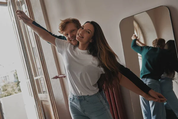 Belo Jovem Casal Mãos Dadas Sorrindo Enquanto Divertindo Casa Juntos — Fotografia de Stock