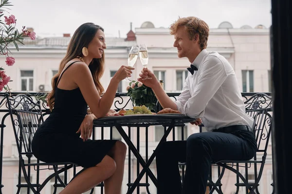 Fiatal Szerelmesek Pezsgővel Koccintanak Miközben Romantikus Vacsorát Vacsoráznak Erkélyen — Stock Fotó