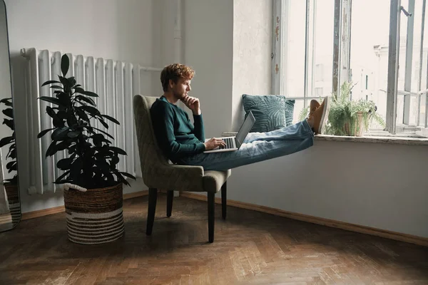 Yakışıklı Genç Adam Dizüstü Bilgisayar Kullanıyor Evdeki Sandalyede Otururken Ele — Stok fotoğraf