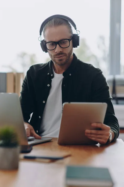 Důvěryhodný Muž Sluchátkách Využívající Technologie Když Sedí Svém Pracovišti Kanceláři — Stock fotografie