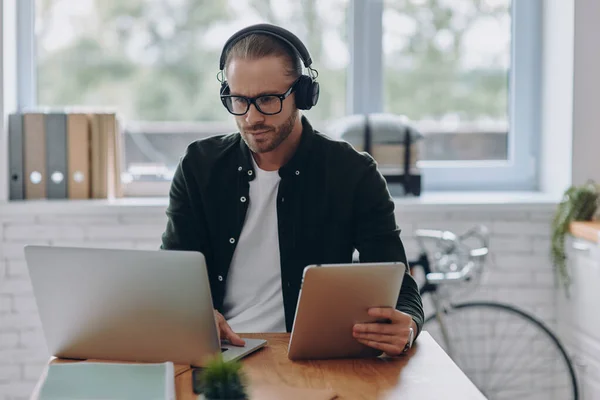 Hombre Concentrado Auriculares Usando Tecnologías Mientras Está Sentado Lugar Trabajo — Foto de Stock
