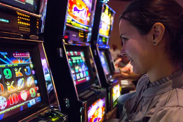 幸运的女人玩老虎机的赌场 图库照片