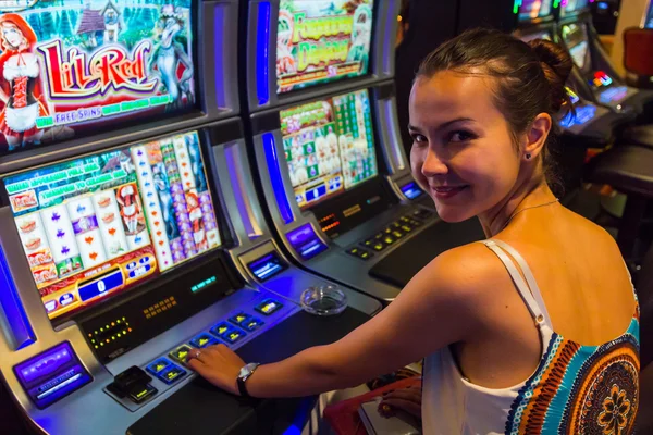 Smiling woman playing slot machines — Stock Photo, Image