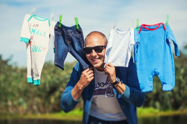 Padre escondido entre la ropa de su hijo —  Fotos de Stock