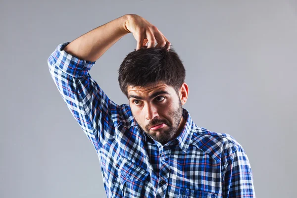 Funny man thinking while scratchin his head — Stock Photo, Image