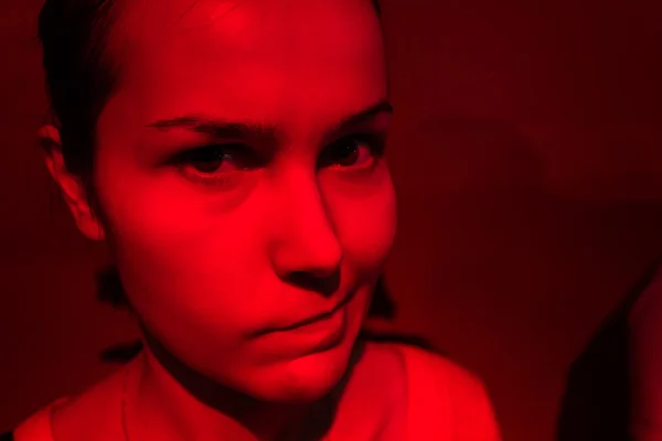 Chagrijnig vrouw portret in rood licht — Stockfoto