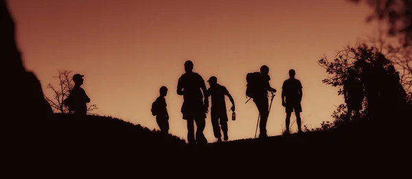 Alacakaranlıkta insanlar yürüyen silhouettes