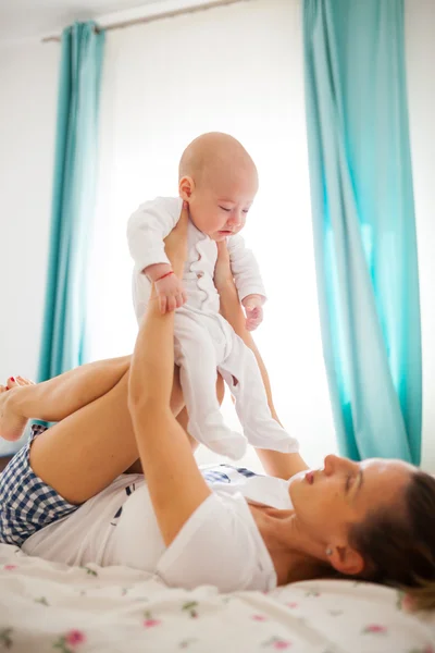 Baby sitzt auf Mamas Knien — Stockfoto