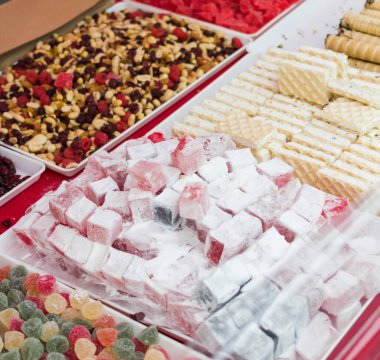 Vitrinin arkasındaki beyaz tepsilerde birçok çeşit tatlı var..