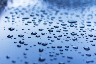 Mavimsi metalik arkaplanda su damlaları.