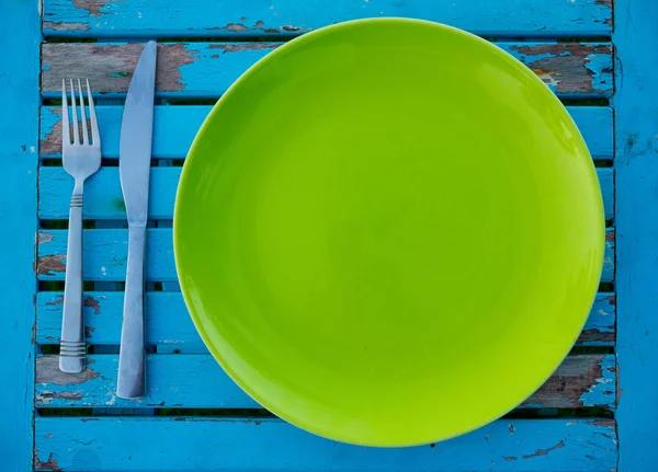 Зеленая плита на голубом столе — стоковое фото
