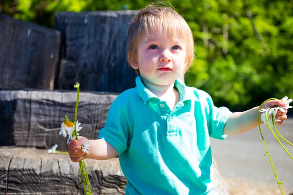 Ragazzo giocare con i fiori — Foto Stock