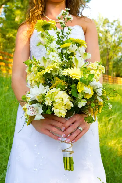 Braut hält Blumenstrauß — Stockfoto