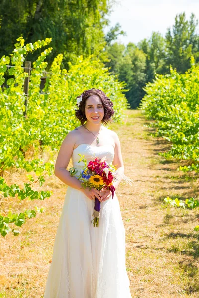 Mooie bruid bedrijf bloemen — Stockfoto