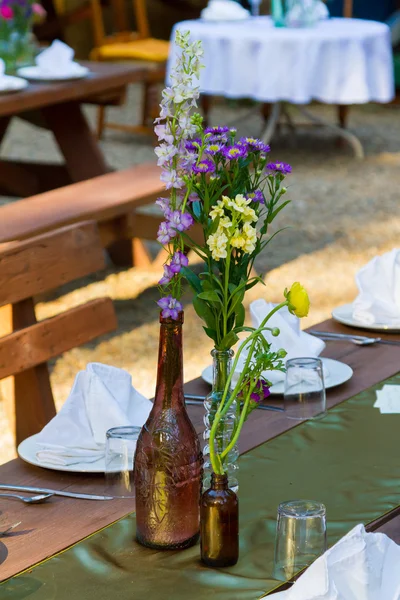Винтажные бутылки и цветы в центре — стоковое фото