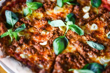 tasty bolognese pizza with fresh basil