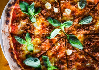 tasty bolognese pizza with fresh basil