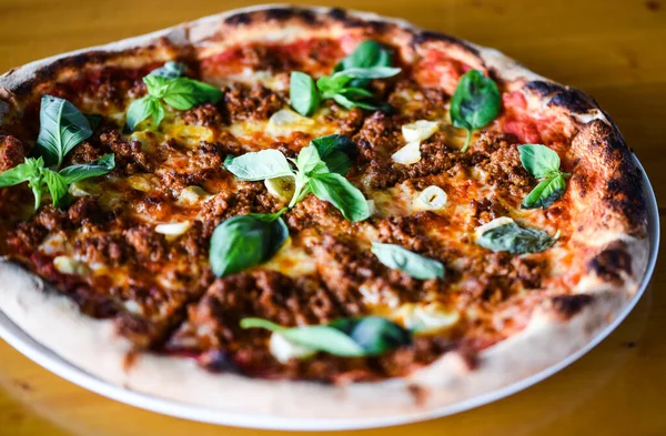 tasty bolognese pizza with fresh basil