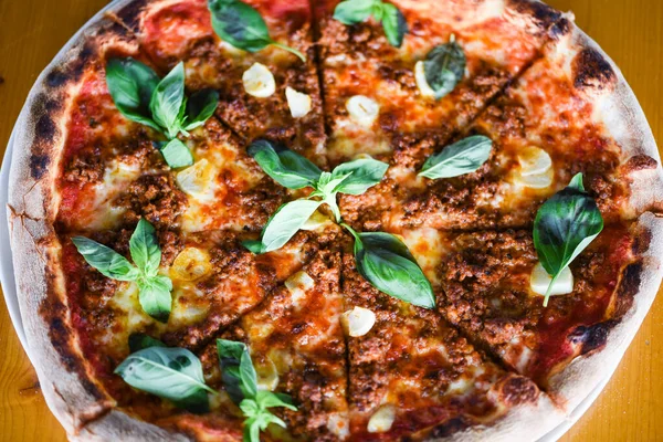 tasty bolognese pizza with fresh basil
