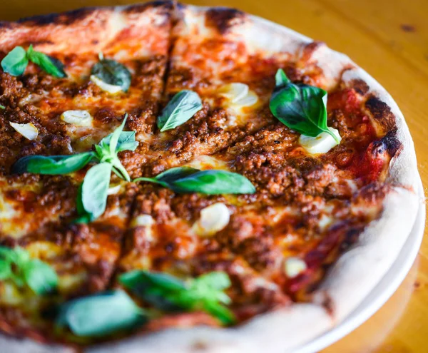 tasty bolognese pizza with fresh basil