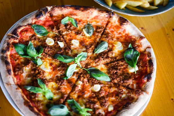 tasty bolognese pizza with fresh basil
