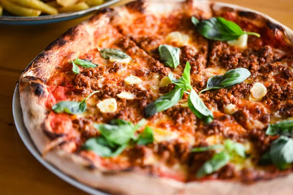 tasty bolognese pizza with fresh basil