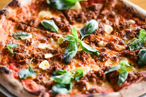 tasty bolognese pizza with fresh basil