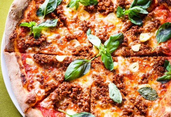 tasty bolognese pizza with fresh basil