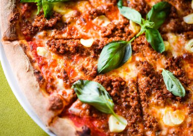 tasty bolognese pizza with fresh basil