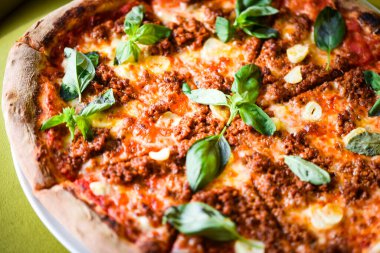 tasty bolognese pizza with fresh basil