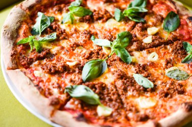 tasty bolognese pizza with fresh basil