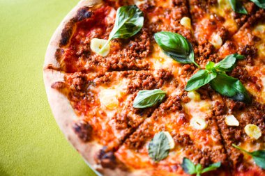 tasty bolognese pizza with fresh basil