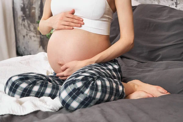 Cropped Shot Pregnant Woman Striped Pants White Top Sitting Bed — Stock Photo, Image