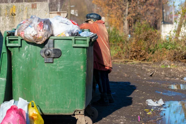 俄罗斯尤里耶夫 波尔斯基 一名在垃圾桶边的老年妇女正在寻找食物和衣服 — 图库照片