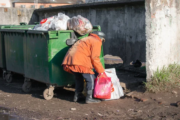 Yuryev-Polsky, Rusya, 10.30.2021 çöp tenekelerinde yaşlı bir kadın yiyecek ve giyecek arıyor.