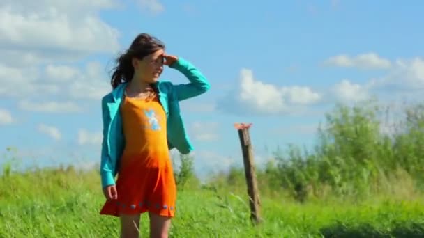 Menina fica na costa na grama — Vídeo de Stock