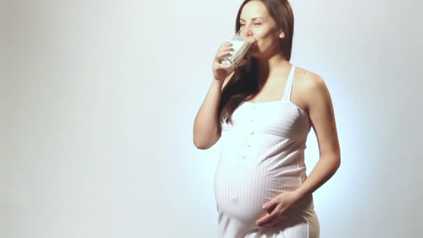 Беременная женщина пьет молоко, женщина пьет сок во время беременности — стоковое видео