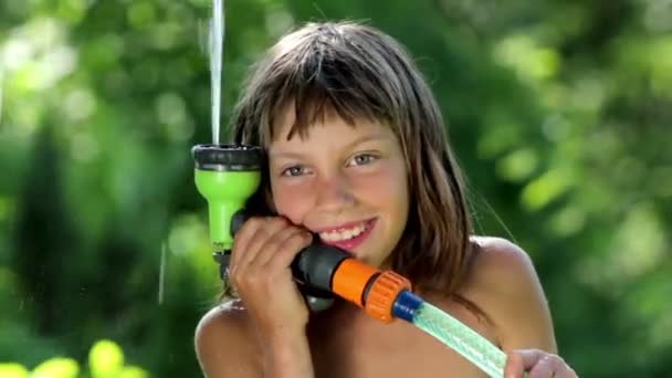 Jongen spelen met water in de tuin, jongen zijn gezicht wassen — Stockvideo