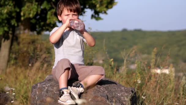 Boy drinkin mineral water from plastic bottle — Stock Video