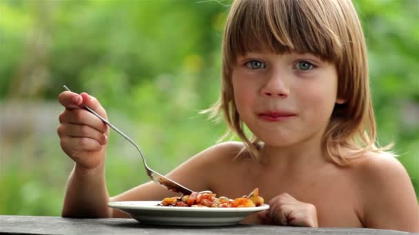 Jongen eten fruit, jongen met eetlust eet gezond voedsel buiten — Stockvideo